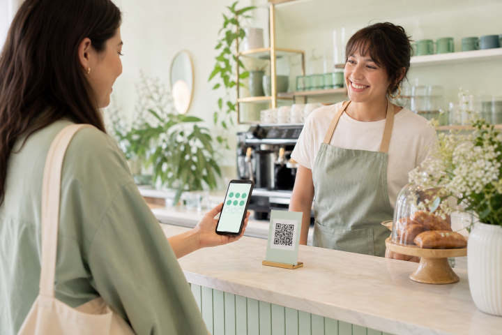 Customer scanning a QR code at a cafe counter to collect a stamp